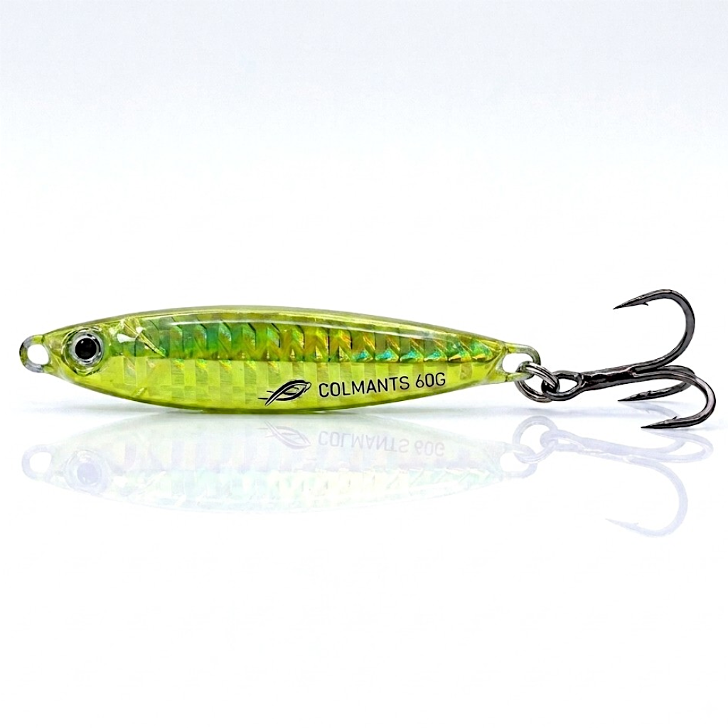 A metallic green and yellow fishing lure with black triple hooks, shown on a reflective white background. The lure has the brand name 'COLMANTS' printed on its side. Chartreuse Metal Jig. Long Casting
