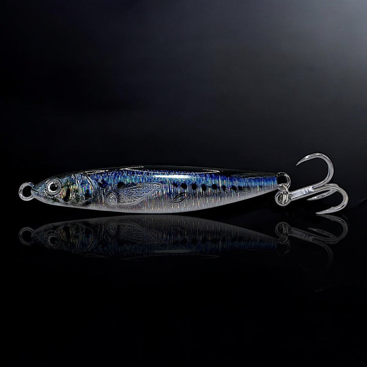 A silver-colored artificial fishing jig designed to resemble a baitfish, with reflective patterns and a hook protruding from the rear. Dartsting Sardine